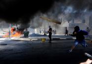 <p>Palestinian protestors burn tyres and throw rocks with slingshots in response to Israeli forces’ intervention during a protest, organized to mark 70th anniversary of Nakba, also known as Day of the Catastrophe in 1948, and against United States’ plans to relocate the U.S. Embassy from Tel Aviv to Jerusalem in Bethlehem, West Bank on May 15, 2018. (Photo: Wisam Hashlamoun/Anadolu Agency/Getty Images) </p>