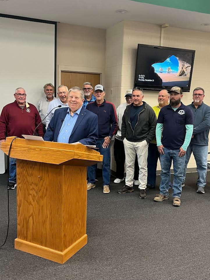 Backed by fellow members of the North Santa Rosa Utility Coalition, spokesman Robert Smith of the Point Baker Utility prepares to speak against legislation proposed by state Sen. Doug Broxson that would create a regional utility authority in North Santa Rosa County.