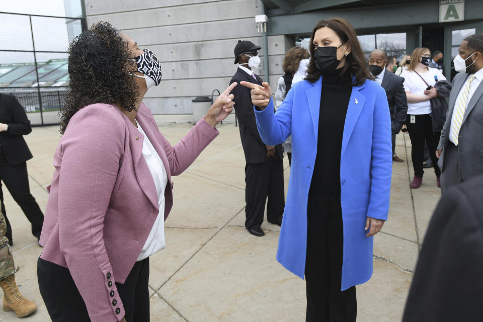 Michigan Governor Gretchen Whitmer, right, shares a laugh with State Rep. (District 55) Felicia Brabeck, outside the Eastern Michigan University Convocation Center, Monday, April 12, 2021, where Whitmer and U.S. Rep. Debbie Dingell were visiting with volunteers and local civic leaders at the COVID-19 Vaccination Clinic set up inside the center. (Lon Horwedel/Detroit News via AP)