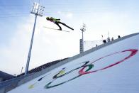 Vinzenz Geiger, of Germany, soars through the air during the competition round of the individual Gundersen large hill/10km ski jumping competition at the 2022 Winter Olympics, Tuesday, Feb. 15, 2022, in Zhangjiakou, China. (AP Photo/Andrew Medichini)