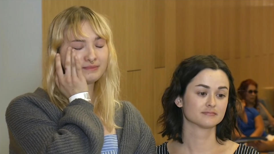 This photo taken from video provided by KGO-TV shows Brynn Ota-Mathews, 23, left, and Gabriella Gaus, 26, both wounded in the mass shooting at the Gilroy Garlic Festival, as they talk about their experience at Santa Clara Valley Regional Medical Center in Santa Clara, Calif., Thursday, Aug. 1, 2019. (KGO-TV via AP)
