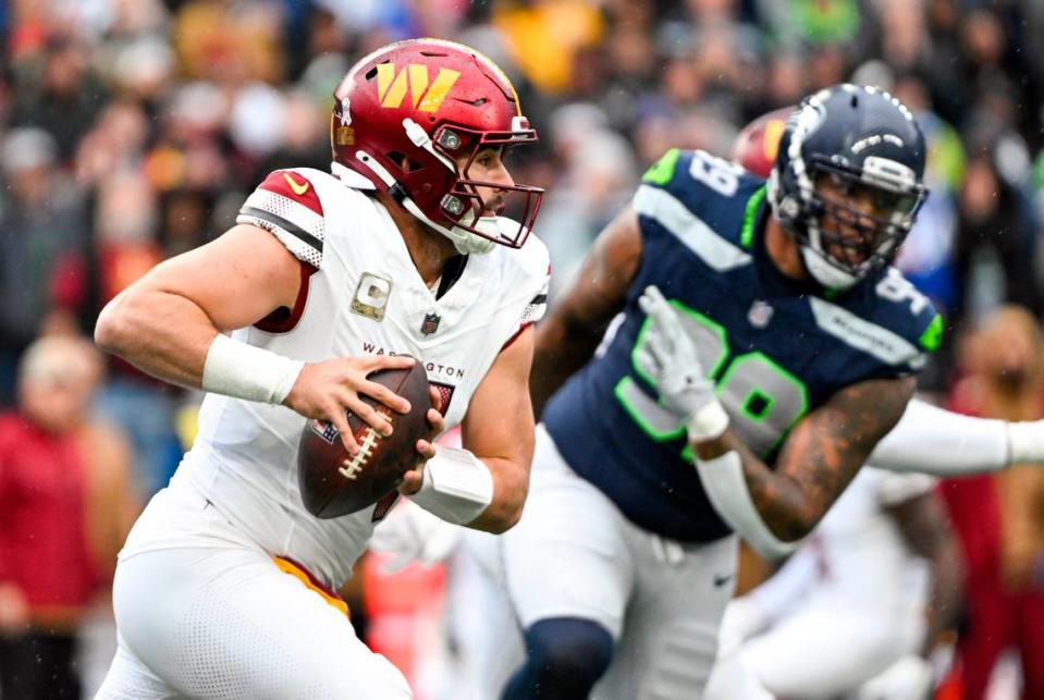 Washington Commanders quarterback Sam Howell (14) scrambles during the first quarter of the game against the Seattle Seahawks at Lumen Field, on Sunday, Nov. 12, 2023, in Seattle, Wash.