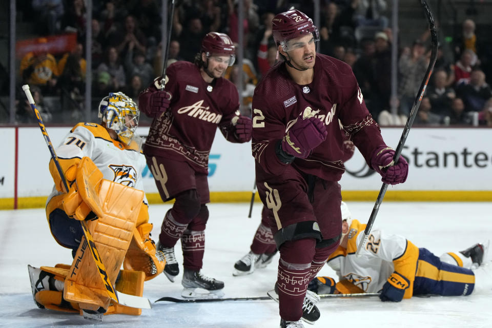 Arizona Coyotes center Jack McBain (22) celebrates after scoring a goal on Nashville Predators goaltender Juuse Saros (74) during the first period of an NHL hockey game Thursday, March 28, 2024, in Tempe, Ariz. (AP Photo/Rick Scuteri)