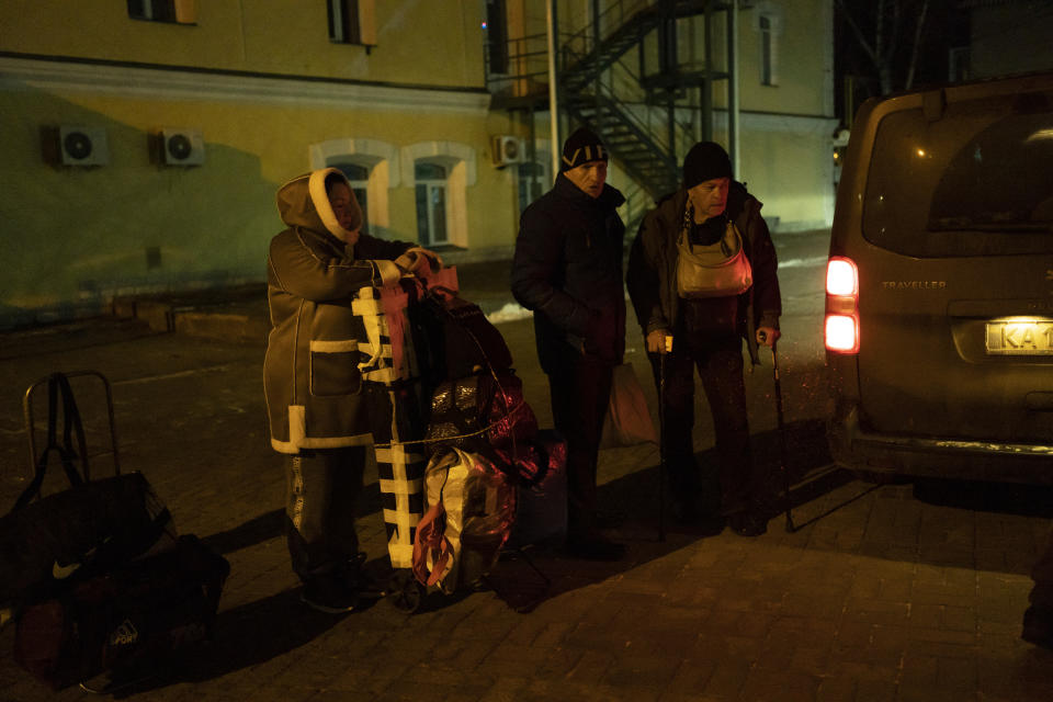 People wait to load their luggage into an evacuation bus in Sumy, Ukraine, Thursday, Nov. 23, 2023. An average of 80-120 people return daily to Ukraine from territories held by Russia through an unofficial crossing point between the two countries amid a brutal war. Most choose this challenging path, even in freezing temperatures, to escape Russian occupation and reunite with their relatives in Ukraine. (AP Photo/Hanna Arhirova)