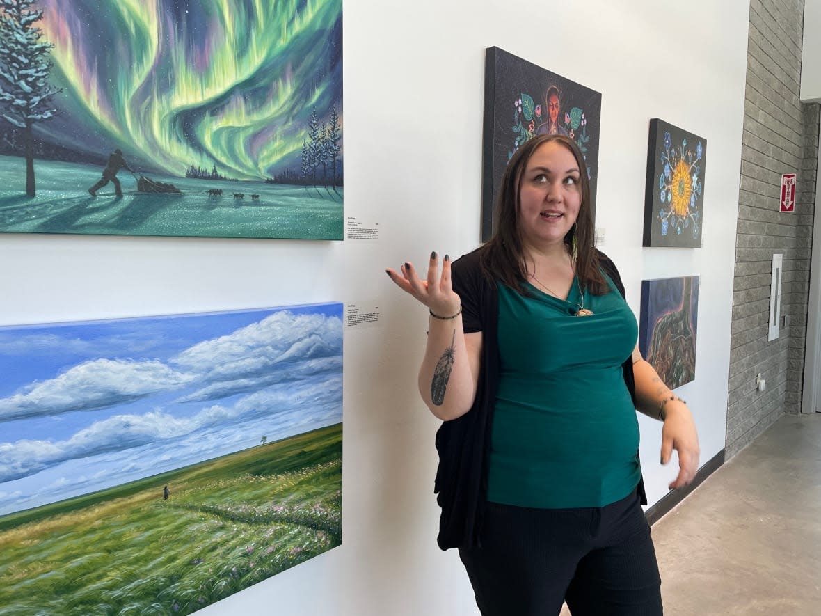 Artist Erin Stagg speaks about her new exhibit at Two Rivers Gallery in Prince George, B.C. The exhibit is called Otipemisewak: The People Who Own Themselves. It illustrates stories of the Métis people through Stagg’s own family history. (Nicole Oud/CBC - image credit)