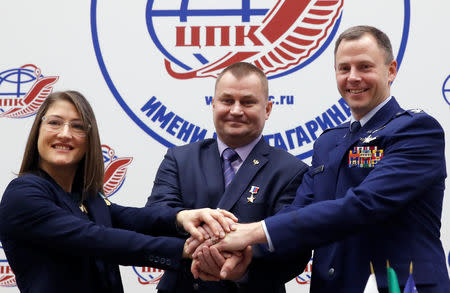 International Space Station (ISS) crew members Aleksey Ovchinin of Russia and Nick Hague of the U.S., along with Christina Koch of the U.S. pose for a photograph during a news conference in the Star City near Moscow, Russia February 21, 2019. REUTERS/Maxim Shemetov