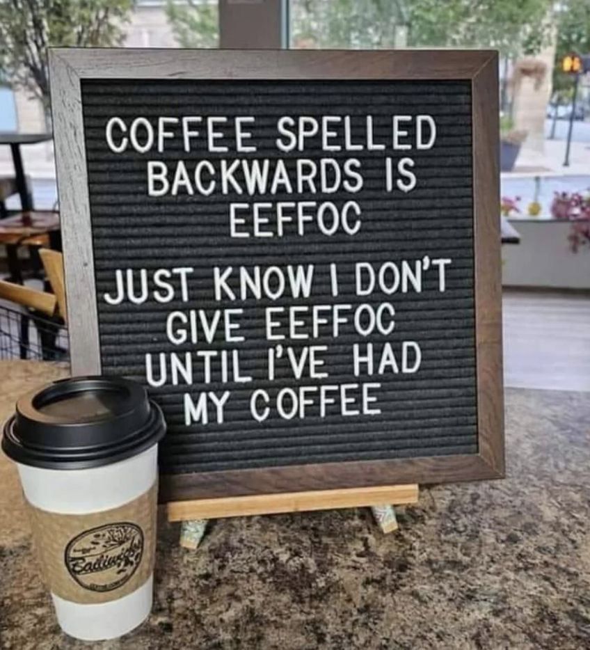 Humorous sign reading "Coffee spelled backwards is eeffoc... I don't give eeffoc until I've had my coffee" with a coffee cup