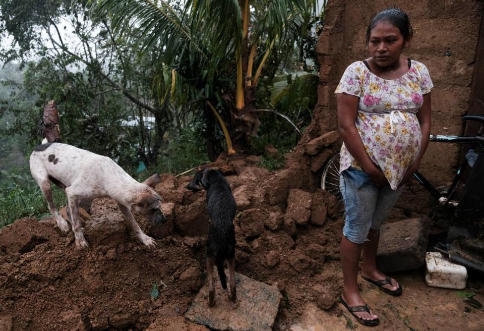 A woman stands by the fallen wall of her house after the passage of Hurricane Iota in Siuna, Nicaragua, Tuesday, Nov. 17, 2020.
