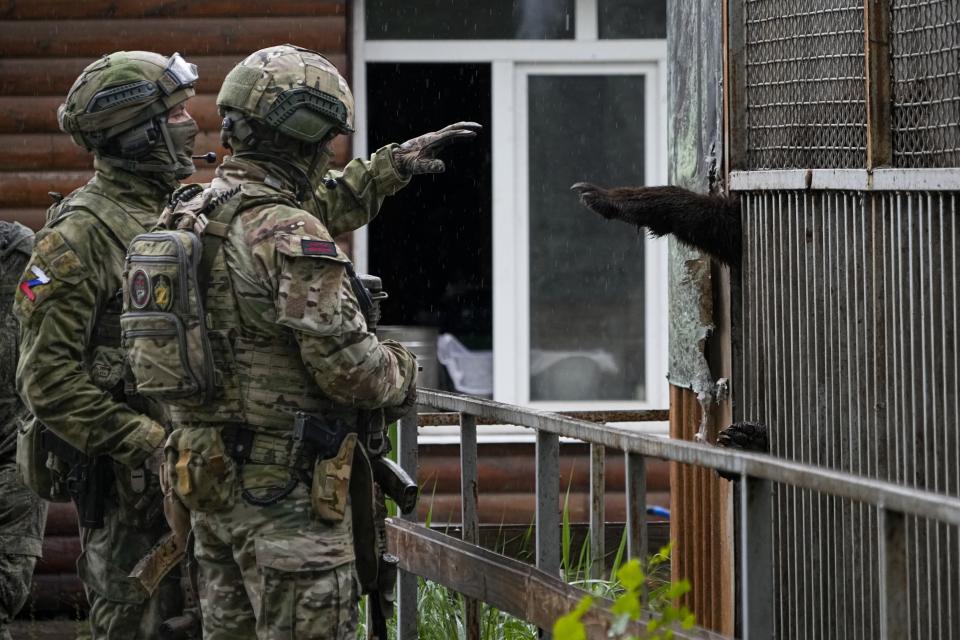 Soldados rusos juegan con un oso el miércoles 18 de mayo de 2022 en el zoológico de Mariúpol, en territorio bajo el gobierno de la República Popular de Donetsk, en el este de Ucrania. Esta foto fue tomada durante un viaje organizado por el Ministerio de Defensa ruso. (Foto AP)