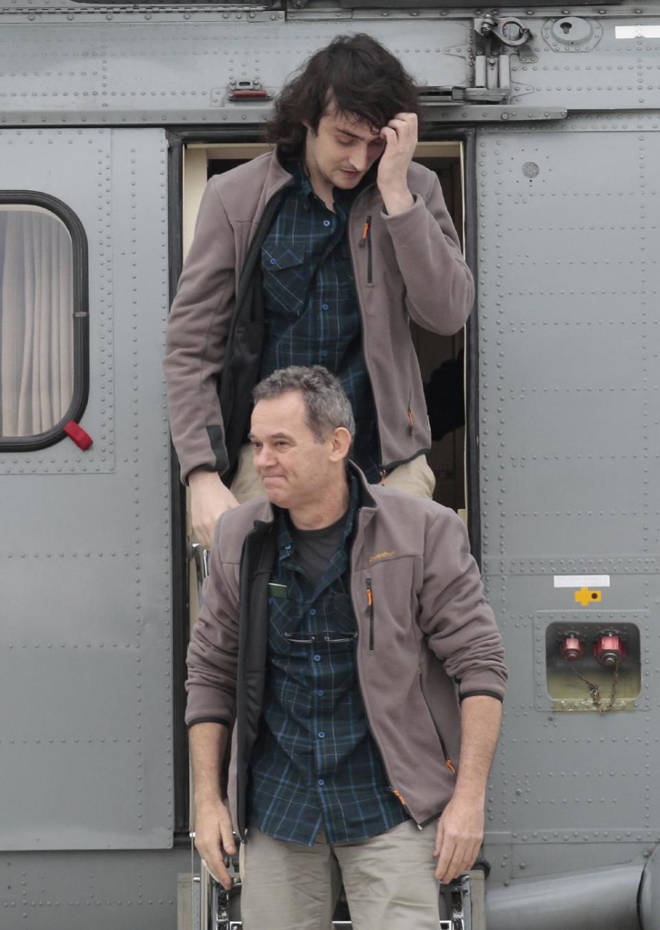 Released French hostage Didier Francois, bottom, and Edouard Elias arrive at the Villacoublay military airbase, outside Paris, Sunday April 20, 2014. Four French journalists, including them, kidnapped and held for 10 months in Syria returned home on Sunday to joyful families awaiting them. The four were freed by their captives a day earlier at the Turkish border. (AP Photo/Jacques Brinon)