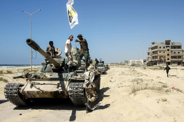 Members of the self-styled Libyan National Army, loyal to eastern strongman Khalifa Haftar, ride a tank in the eastern city of Benghazi on July 5, 2017