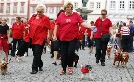 Residents smile as they walk their dogs during a Sunday Parade in Eichstaett September 8, 2013. REUTERS/Michael Dalder (