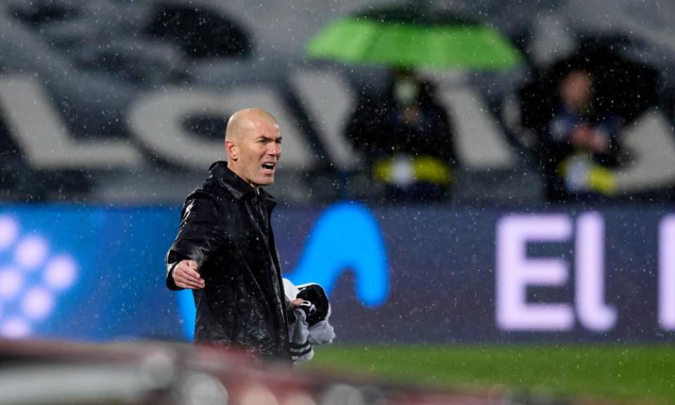 Zinedine Zidane watches his Real Madrid team in the rain against Barcelona