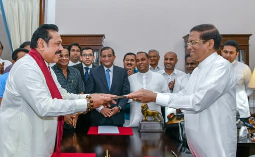 Former Sri Lankan president Mahinda Rajapakse, left, is sworn is as prime minister by President Maithripala Sirisena