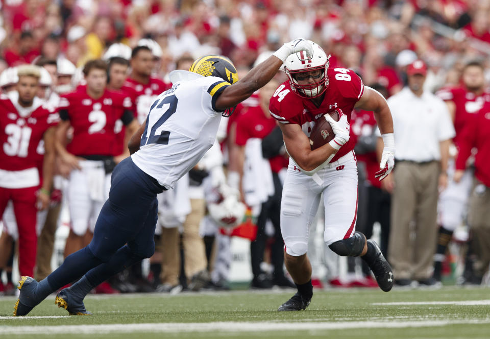 Oct. 2, 2021; Madison, Wisconsin; Wisconsin Badgers tight end Jake Ferguson (84) rushes with the football after catching a pass as Michigan Wolverines linebacker Josh Ross (12) defends during the second quarter at Camp Randall Stadium. Jeff Hanisch-USA TODAY Sports