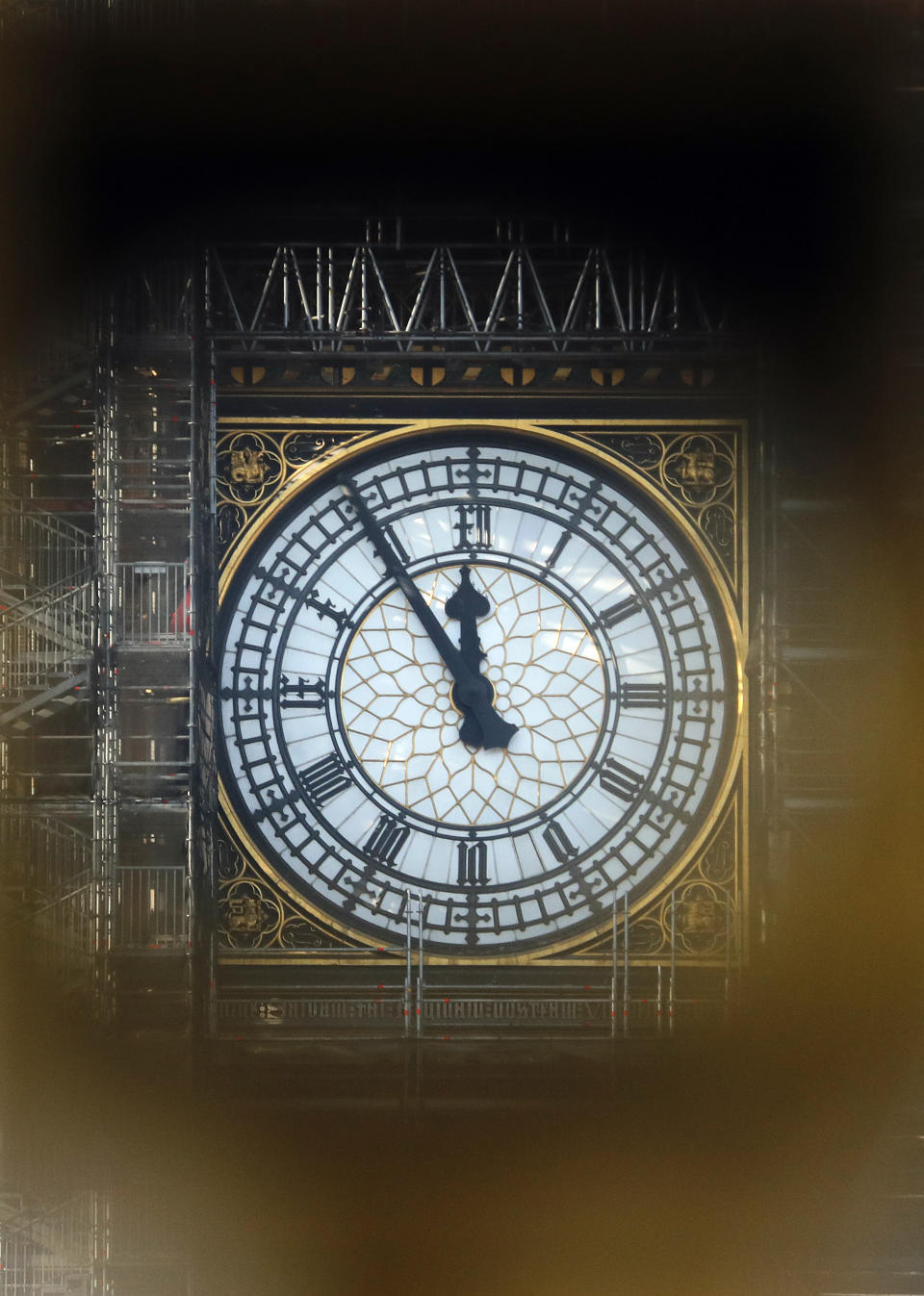 The Big Ben's clock shows five minutes to twelve, photographed through a binocular stand in London, Tuesday, Jan. 22, 2019. British Prime Minister Theresa May launched a mission to resuscitate her rejected European Union Brexit divorce deal, setting out plans to get it approved by Parliament. (AP Photo/Frank Augstein)