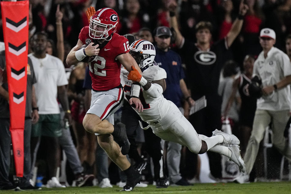 Georgia quarterback Brock Vandagriff (12) is stopped by Tennessee-Martin safety Robert Daniel Jr., right, during the second half of an NCAA college football game Saturday, Sept. 2, 2023, in Athens, Ga. (AP Photo/John Bazemore)