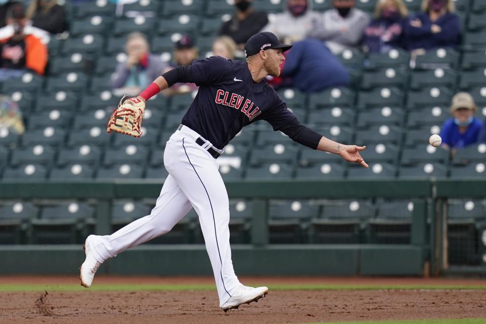 Cleveland Indians first baseman Jake Bauers flips the ball to Indians starting pitcher Zach Plesac to get San Francisco Giants' Mike Yastrzemski out at first base during the third inning of a spring training baseball game Tuesday, March 23, 2021, in Goodyear, Ariz. (AP Photo/Ross D. Franklin)