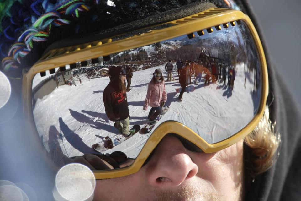 This Nov. 13, 2012 photo shows the reflection of skiers as they gather in line for the chair lift during the first day of their ski season at the Brighton Ski Resort in the Wasatch Range, in Utah. The Brighton Ski Resort is in middle of the Wasatch Range's 7 resorts. If the resorts were to be combined, the Utah resorts could offer North America's largest skiing complex _ three times the size of Vail and twice as big as Whistler Blackcomb in British Columbia. (AP Photo/Rick Bowmer)