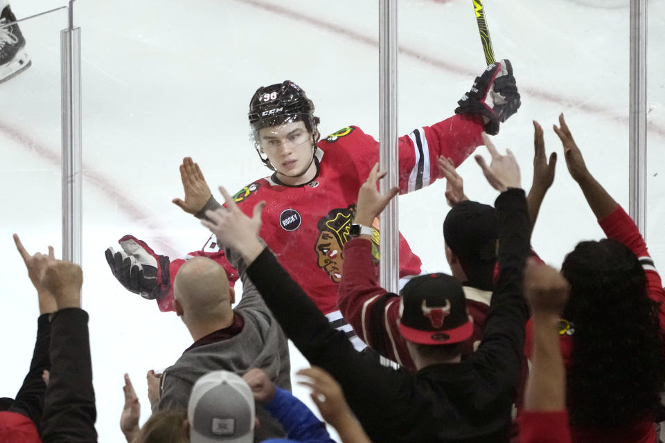 Chicago Blackhawks' Connor Bedard celebrates his goal against the Florida Panthers with fans during the second period of an NHL hockey game Saturday, Nov. 4, 2023, in Chicago. (AP Photo/Charles Rex Arbogast)