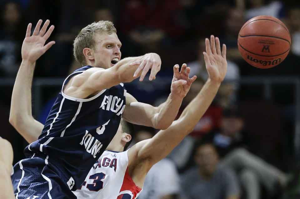 BYU's Tyler Haws, left, passes off the ball against Gonzaga's Drew Barham in the first half of the NCAA West Coast Conference tournament championship college basketball game, Tuesday, March 11, 2014, in Las Vegas. (AP Photo/Julie Jacobson)