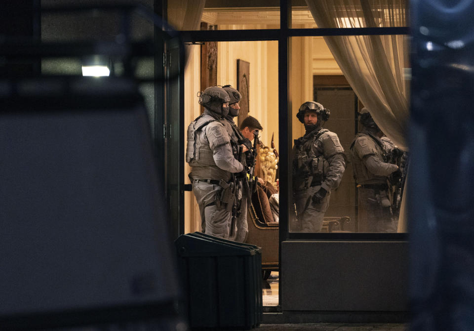 York Regional Police tactical officers stand in the lobby of a condominium building in Vaughan, Ontario, Sunday, Dec. 18, 2022. Police said multiple people are dead, including the suspect, after a shooting in a unit of the building. (Arlyn McAdorey/The Canadian Press via AP)