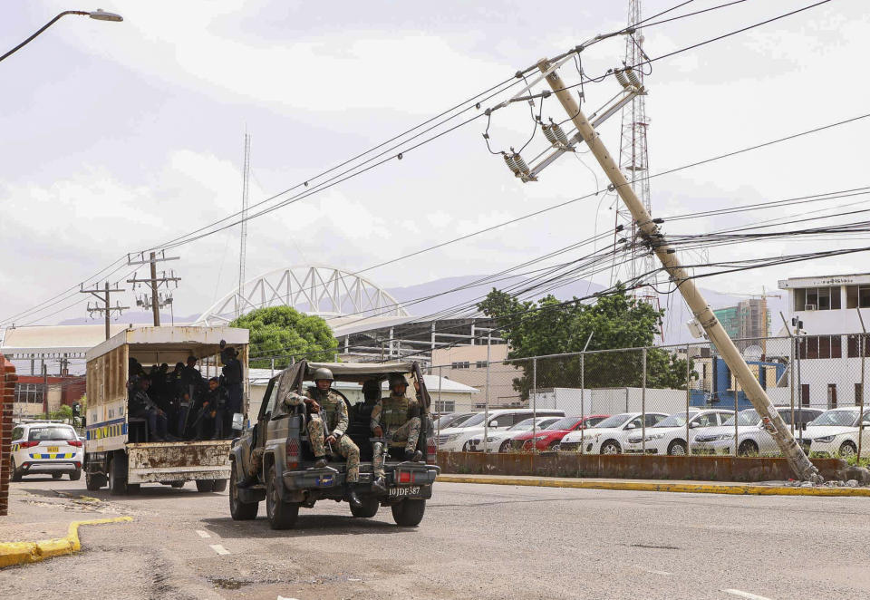 Soldiers on patrol ride past a leaning utility pole in the aftermath of Hurricane Beryl in Kingston, Jamaica, Thursday, July 4, 2024. (AP Photo/Leo Hudson)