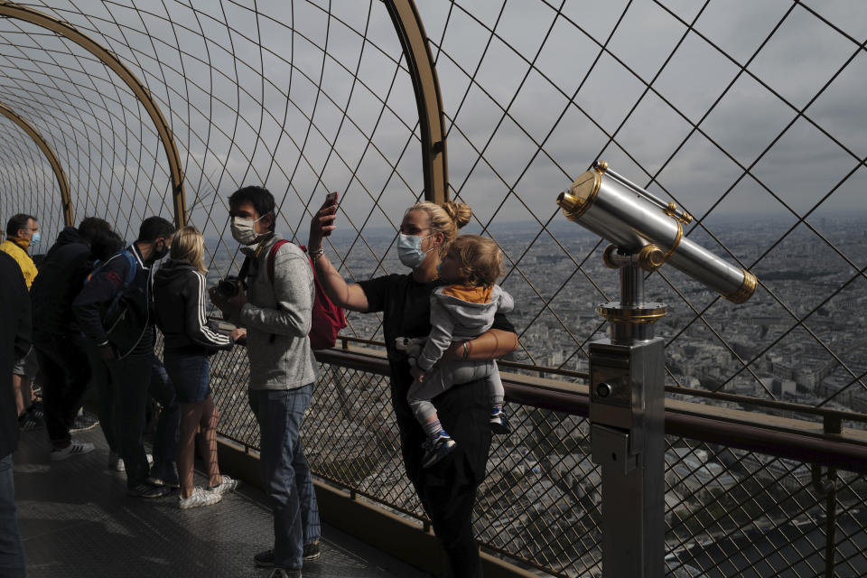 French visitors take a selfie from the third level during the opening up of the top floor of the Eiffel Tower, Wednesday, July 15, 2020 in Paris. The top floor of Paris' Eiffel Tower reopened today as the 19th century iron monument re-opened its first two floors on June 26 following its longest closure since World War II. (AP Photo/Francois Mori)