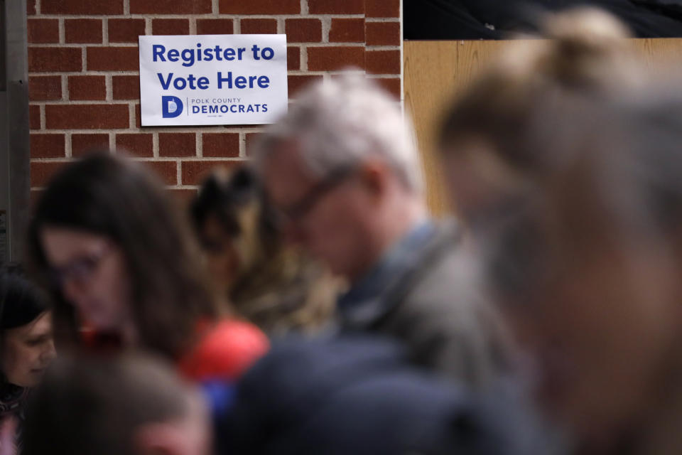 Caucus goers arrive at a caucus at Roosevelt Hight School, Monday, Feb. 3, 2020, in Des Moines, Iowa. (AP Photo/Andrew Harnik)