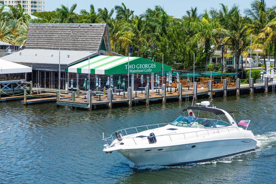 A boat cruises by Two Georges at the Boynton Harbor Marina.