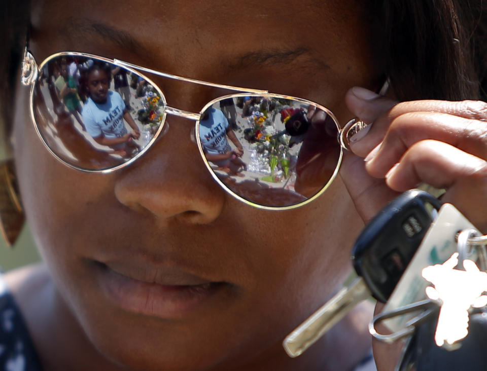 Natasha Wright speaks to her two daughters, Thursday, June 18, 2015 at a make-shift memorial near the Emanuel AME Church in Charleston, S.C.  Dylann Storm Roof, 21, was arrested Thursday in the slayings of several people, including the pastor, at a prayer meeting inside the historic black church in downtown Charleston. (AP Photo/Stephen B. Morton)