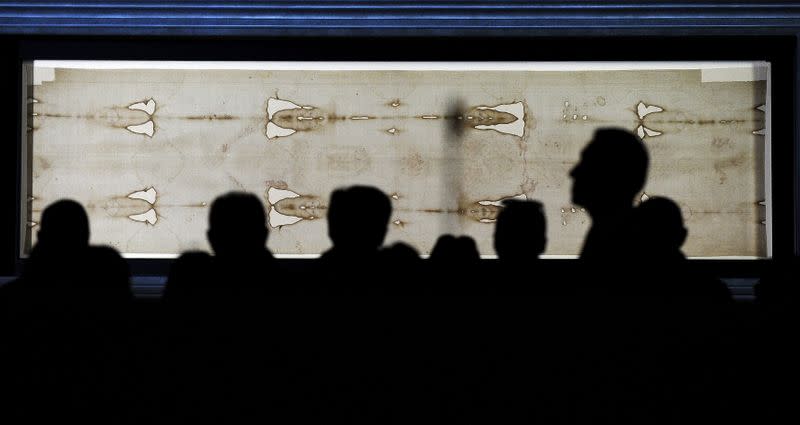 FILE PHOTO: Faithfuls look at the Holy Shroud in the Cathedral of Turin during the opening day of the exposition