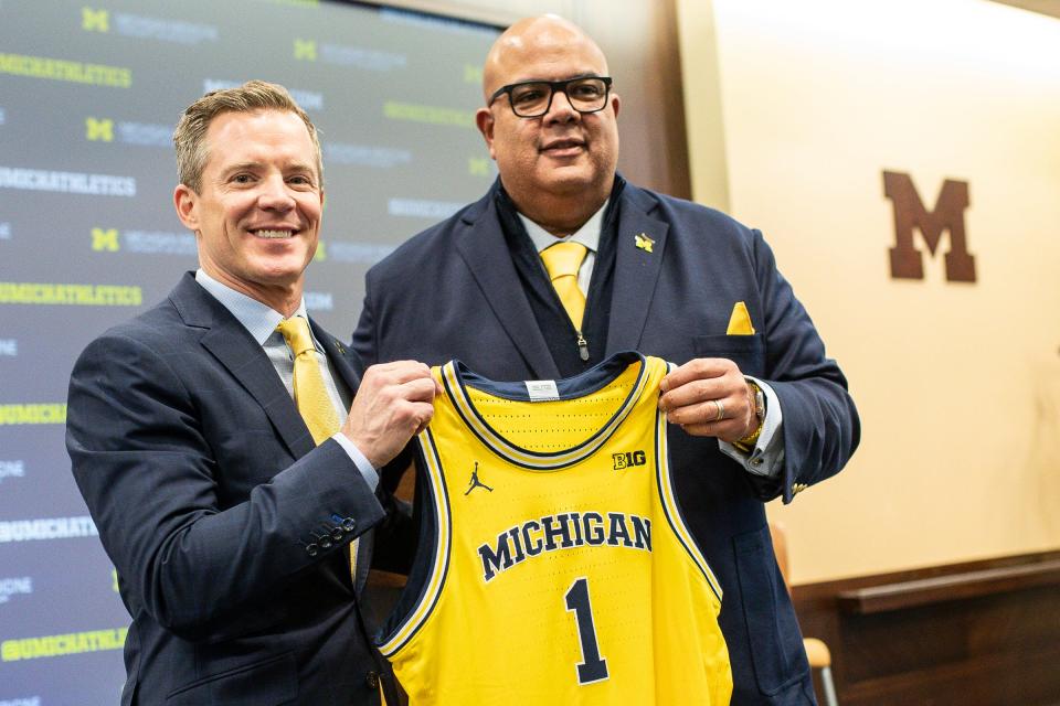 U-M athletic director Warde Manuel presents a jersey to new men's basketball head coach Dusty May during an introductory press conference for Dusty May at Junge Family Champions Center in Ann Arbor on Tuesday, March 26, 2024.