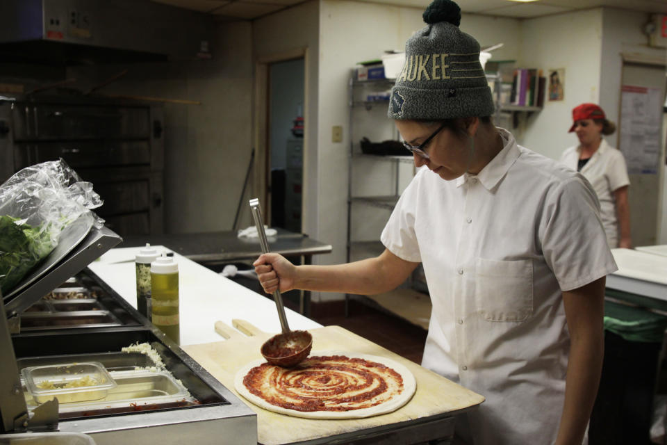 <p> In this Jan. 9, 2017, photo, Andrea Ledesma spreads sauce on pizza dough at Classic Slice restaurant in Milwaukee. The 28-year-old has a four-year degree and quit a higher paying job because it made her miserable. Ledesma thought she would be making more at this point in her life and she's not alone. With a median household income of $40,581, millennials earn 20 percent less than boomers did at the same stage of life, despite being better educated, according to a new analysis of Federal Reserve data by the advocacy group Young Invincibles. (AP Photo/Carrie Antlfinger) </p>