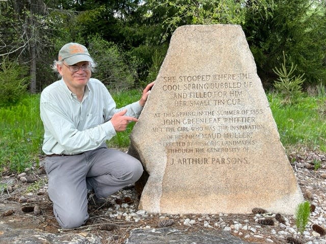 James Kences poses for a photo next to a granite marker on Cider Hill Road that identifies the spot where John Greenleaf Whittier was inspired to write “Maude Muller’s Spring.”