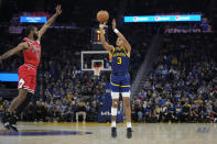 Golden State Warriors guard Jordan Poole (3) shoots a 3-point basket next to Chicago Bulls guard Coby White (0) during the first half of an NBA basketball game in San Francisco, Friday, Dec. 2, 2022. (AP Photo/Godofredo A. Vásquez)