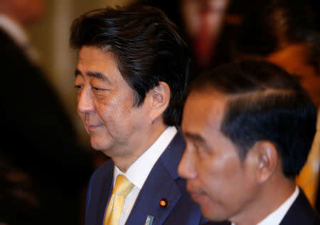 Japanese Prime Minister Shinzo Abe (L) walks with Indonesian President Joko Widodo during a joint news conference at the Bogor Palace, West Java, Indonesia January 15, 2017. REUTERS/Beawiharta