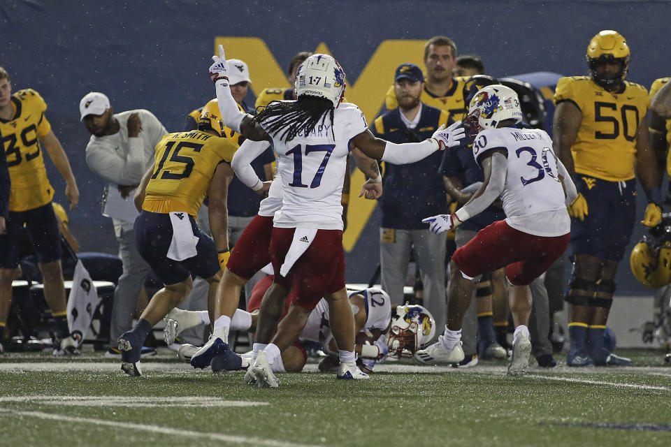 Kansas running back Torry Locklin (12) recovers a fumble by West Virginia wide receiver Reese Smith (15) during the second half of an NCAA college football game in Morgantown, W.Va., Saturday, Sept. 10, 2022. (AP Photo/Kathleen Batten)