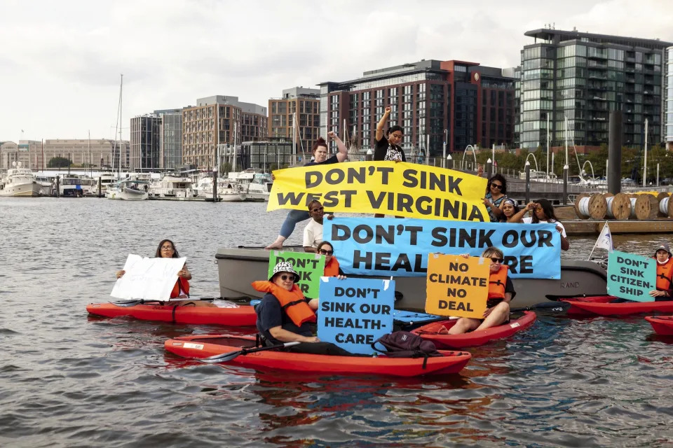 Demonstrators in boats and kayaks protest near Senator Joe Manchin’s houseboat in the Washington marina. Protesters – including some of his constituents from West Virginia – are calling on him to pass the Build Back Better Act and its investments in healthcare, citizenship, and climate solutions. - Credit: Allison Bailey/NurPhoto/AP Images