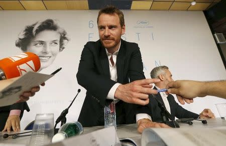 Cast member Michael Fassbender signs autographs to journalists after a news conference for the film "Macbeth" in competition at the 68th Cannes Film Festival in Cannes, southern France, May 23, 2015. REUTERS/Regis Duvignau