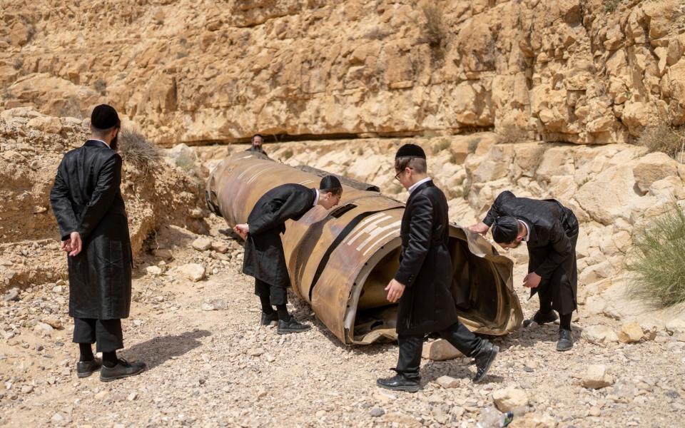 Orthodox Jewish men inspecting an intercepted Iranian ballistic missile