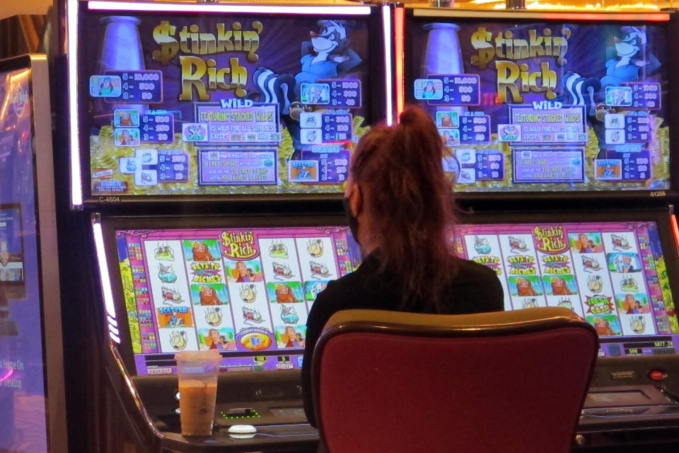 This June 28, 2021 photo shows a gambler playing a slot machine at the Hard Rock casino in Atlantic City, N.J. New Jersey gambling regulators released figures on Thursday, Dec. 16, 2021, showing Atlantic City's casinos have won have won $4.3 billion, up nearly 69% from the same period last year. The numbers came just days before New Jersey legislators are set to vote on significant tax breaks for the casinos. (AP Photo/Wayne Parry)