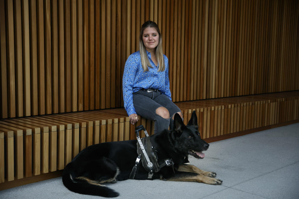 Tabitha Bell, 20, pauses for photos with her 5-year-old service dog, Nox, in Irvine, Calif., Tuesday, Aug. 4, 2020. Bell, a former student with disabilities at an elite private school in Utah, says in a lawsuit that administrators mishandled her 2017 sexual assault allegation as she endured bullying from classmates. She's seeking $10 million in damages. (AP Photo/Jae C. Hong)