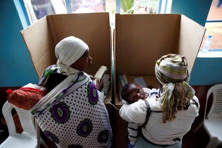 Women carrying babies cast their vote in Gatundu in Kiambu county, Kenya August 8, 2017. REUTERS/Baz Ratner