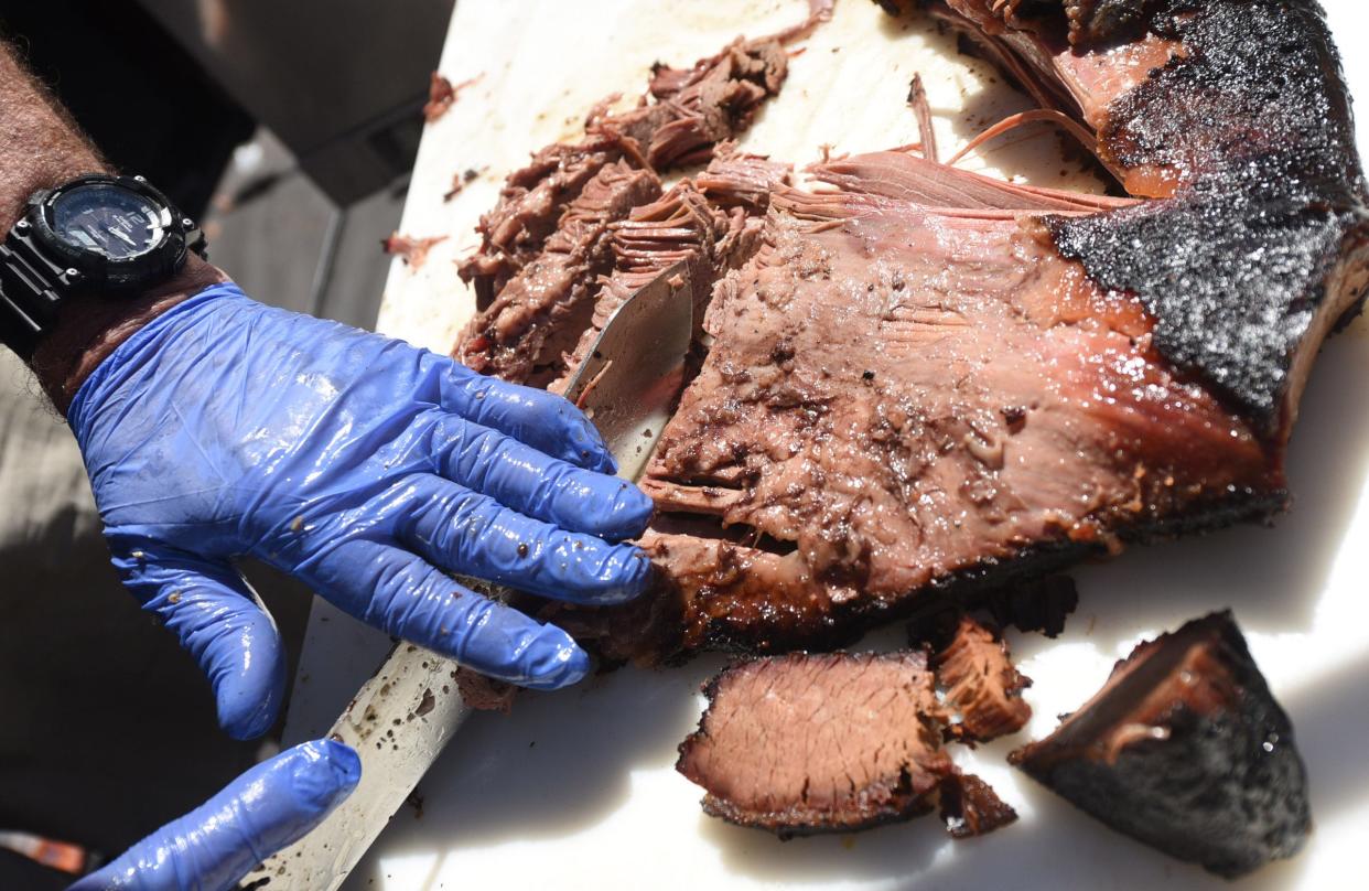 John Crane with Killer Q slices a beef brisket during the second annual Beer, Bourbon & BBQ Festival in downtown Wilmington in 2019.