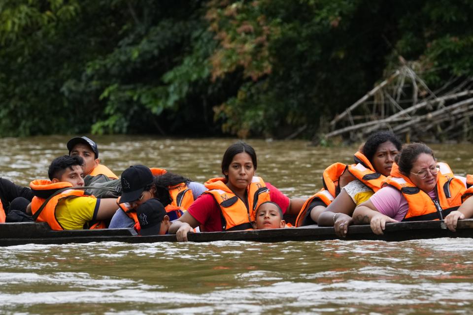 Boats ferry migrants who trekked across the Darien Gap from Colombia, along the Tuquesa River in Panama, Wednesday, Oct. 4, 2023. (AP Photo/Arnulfo Franco)