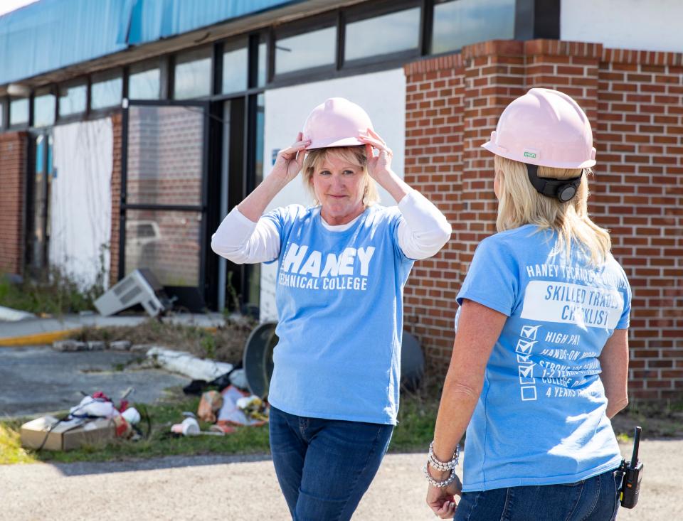 Haney Technical College Director Ann Leonard tries on her pink hard hat, with assistant director Angela Reese, before being the first to knock down a wall at the old nursing building on campus on March 3.