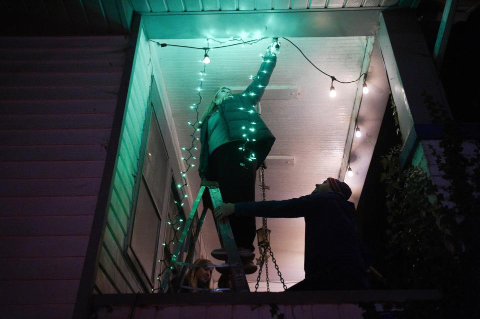 Youth from Sequoyah Hills Presbyterian decorate a home during Light Up Lonsdale, an event held by Thrive, in Lonsdale, Wednesday, Nov. 29, 2023.