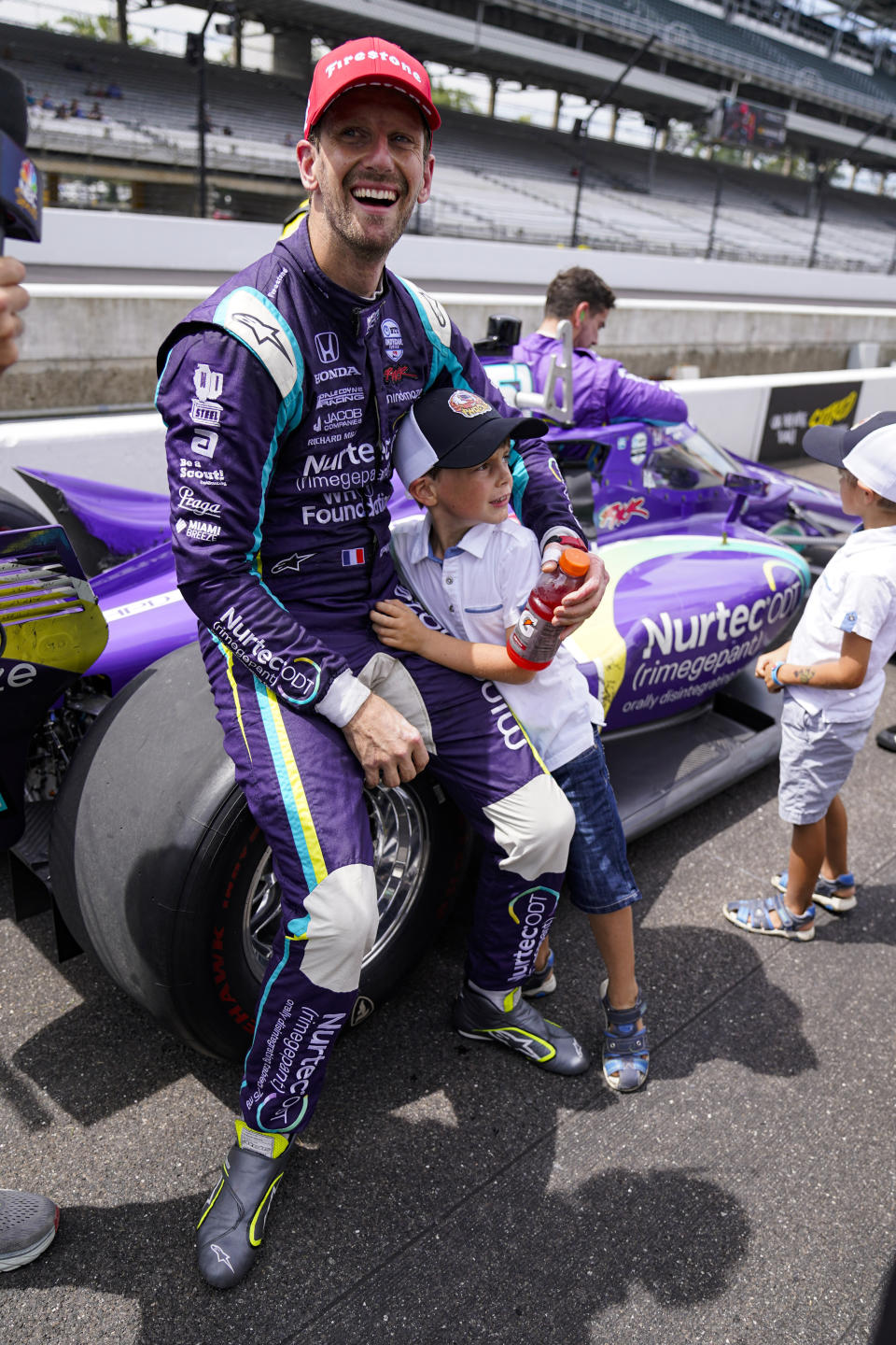 Romain Grosjean, of Switzerland, hugs his son Sacha after finishing second in the IndyCar auto race at Indianapolis Motor Speedway in Indianapolis, Saturday, Aug. 14, 2021. (AP Photo/Michael Conroy)