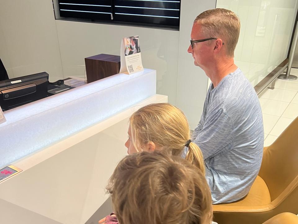 Two kids and an adult sitting at a check-in counter for Etihad airways.